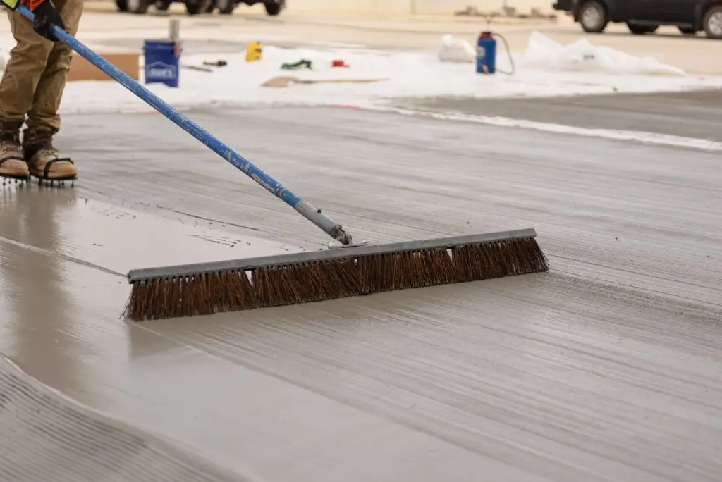 concrete brush creating texture in a thin cement overlay